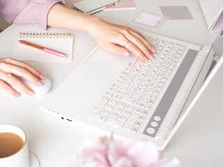 デスクでラップトップを使用する女性の手、可愛い女性のワークスペース、仕事をする女性のコンセプト