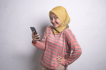 Asian muslim woman wearing hijab using mobile phone