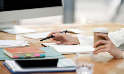 Fototapeta premium young woman writing business papers at desk in modern coworking office. copy space