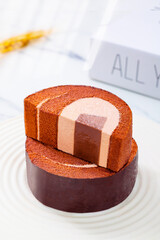 Chocolate swiss cake roll, on a tabletop on a white background, indoors, close-up