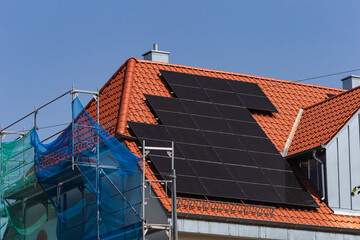 solar panel on building roof with construction scaffold
