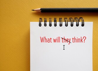 Notebook with handwritten text WHAT WILL THEY THINK? replaced THEY with I, concept of overcoming...