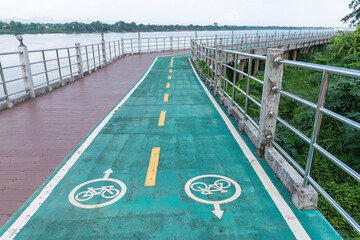 The cycling road next to the river is marked with a bicycle sign.