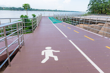 There are 2 bicycle roads next to the river. The pedestrian and bicycle lanes have the symbols of...