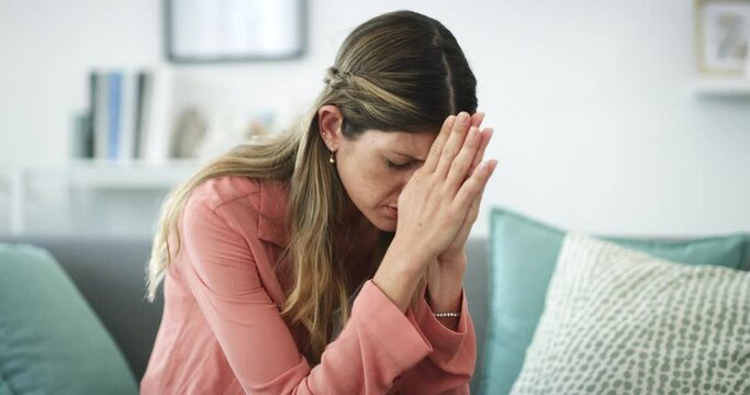 Praying, woman stress and living room sofa with worship and hope for support and faith at home. House, lounge couch and female person with religious prayer and gratitude to god and Christianity trust