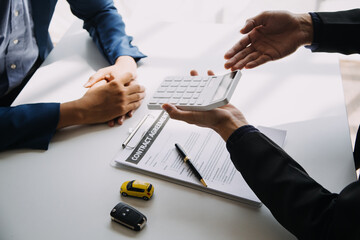 Hand holding car keys and car rental concept A close-up view of the agent, giving the customer the car keys after signing the lease, rental form and car name.