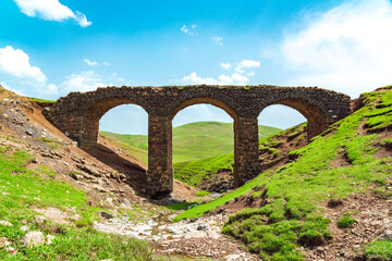 Fototapeta na wymiar An ancient stone bridge in the suburbs of the city of Gadabay, built by the Siemens brothers in 1879 to transport ore to the plant by narrow gauge railway