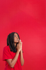 African woman looking up while praying with folded hands