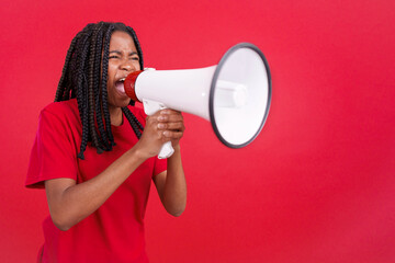 Angry african woman standing and using a megaphone