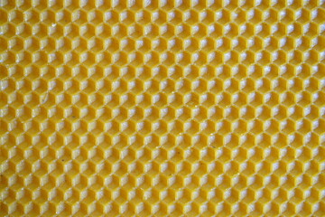 Yellow beeswax sheet background with honeycomb hexagonal pattern