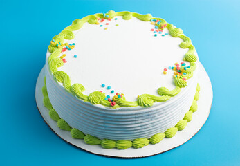 Circular White Ice Cream Cake with Colorful Border and Sprinkles on a Blue Background