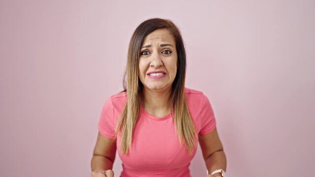 Middle eastern woman standing with winner expression over isolated pink background