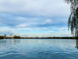 Almost abstract background view of water and sky, a scenic landscape close to sunset of Herastrau Park, in Bucharest, Romania.