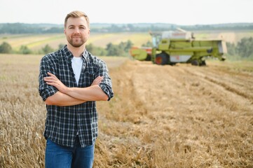 Naklejka na ściany i meble Farmer Standing In Wheat Field At Harvest