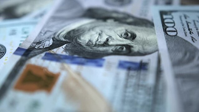 Slow motion close-up 100 American dollars bills. Hundred dollar lies on table. Paper money cash. Importance of financial management in achieving long-term financial goals.