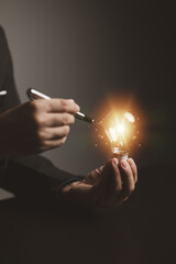 Businessman holding glowing lamp, Creative new idea. Innovation, brainstorming, strategizing to make the business grow and be profitable. Concept execution, strategy planning and profit management.