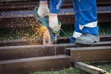 Cutting metal with a grinder. Sparks fly out of the grinder