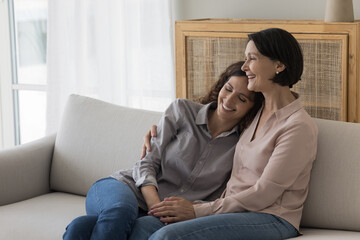 Happy senior mother hugging positive daughter woman with love, care, support, smiling, laughing, talking to adult kid, enjoying family meeting, close relations, bonding, motherhood
