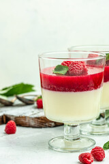 Raspberry sorbet with whipped cream and mint. Italian dessert on a light background in small jars. vertical image. top view. place for text