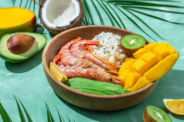 Hawaiian cuisine. Poke with shrimp, avocado, rice, mango, kiwi and coconut. Tropical food. Lunch on...