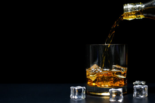 Bartender Poured A Glass Of Whiskey On Wood Bar Counter. 