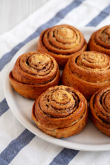 Homemade Cinnamon Roll Pastry on a white wooden background, side view. Close-up.