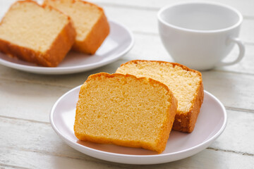 Butter cake sliced on white plate and coffee cup