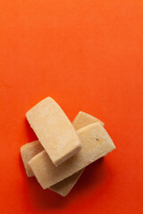 Four sweet and tasty coconut butter cookies, on orange background. Top-down view. Food Flat lay.