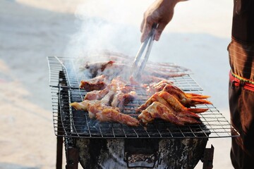 Selective focus of Grilled pork and chicken on a street food grill.