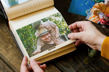 Woman looks at printed photos for family picture album.
