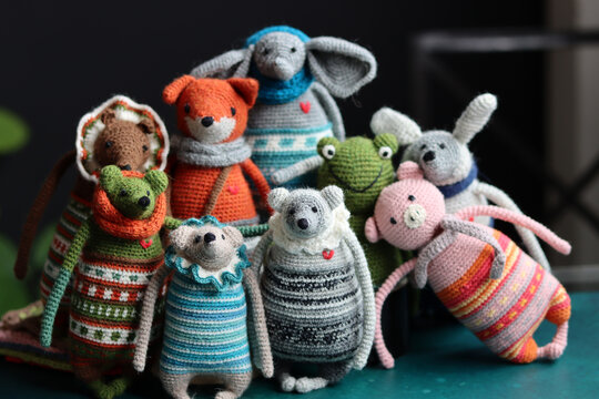 Crochet stuffed animals close up photo. Hand made Amigurumi toys on dark background with copy space. Cute crochet gift. 