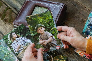 Woman looks at printed photos for family picture album.