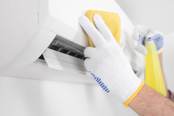 Service guy cleaning and maintaining air condition unit.