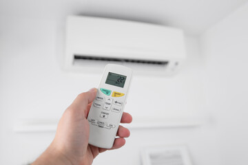 Man holding a modern AC unit remote.