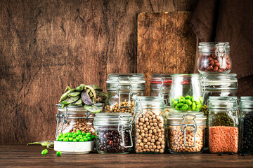 Dried, raw and fresh legumes and beans in glass jars. Lentils, chickpeas, mung beans, soybeans....