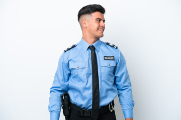 Fototapeta premium Young police caucasian man isolated on white background looking side