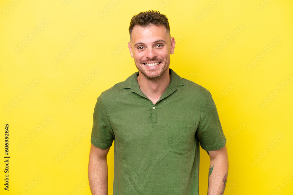 Wall mural Young caucasian handsome man isolated on yellow background laughing