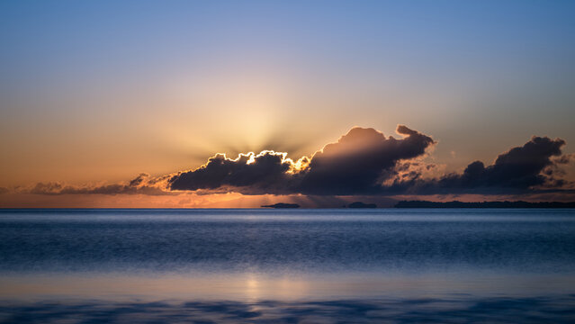 Sunbeams shining through clouds at sunrise. Auckland.
