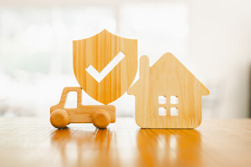 Car and House model with small shield icon on wood table, concepts of contract to buy, get...