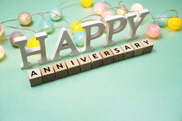 Happy Anniversary alphabet letter with LED cotton balls on green background