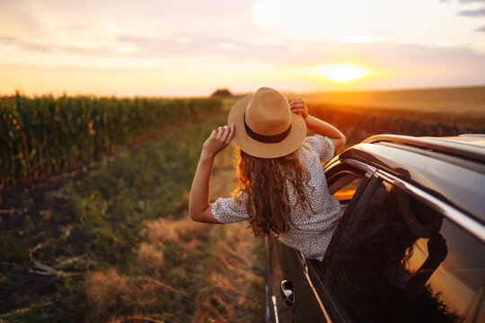 Young woman is resting and enjoying sunset in the car. Woman on the road trip. ifestyle, travel, tourism, nature, active life.
