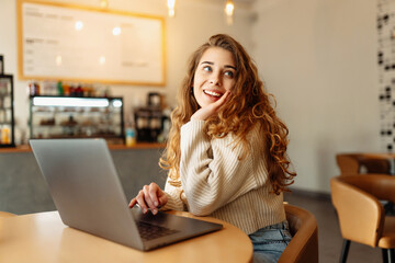 Young woman with laptop in cafe.  Business, blogging, freelancing, education concept.