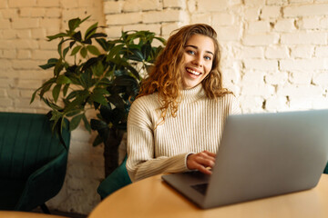 Young woman with laptop in cafe.  Business, blogging, freelancing, education concept.