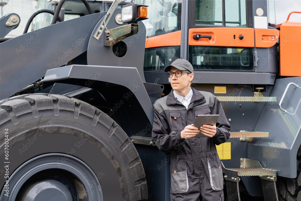 Aufkleber serviceman with digital tablet on a background of the tractor