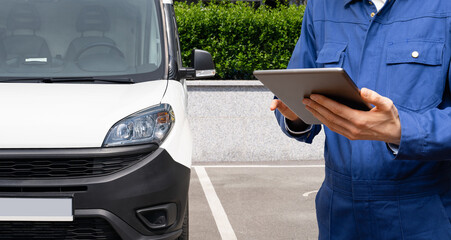 Manager with a digital tablet on the background of delivery van. Fleet management