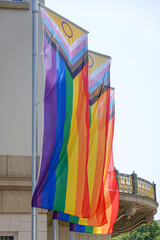 vertical progress pride rainbow flag on flagpole