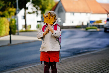 Cute little toddler girl on her first day going to playschool. Healthy happy child walking to...