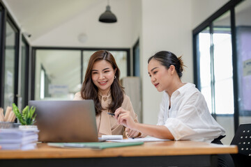 Two business women sit and discuss plans for a new project. Brainstorm and share ideas.