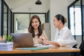 Obraz premium Two business women sit and discuss plans for a new project. Brainstorm and share ideas.