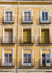 Obraz premium Windows and balconies on a historic yellow house in Teruel, Spain